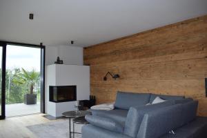 a living room with a blue couch and a tv at FeWo Passo-Palade in Tesimo