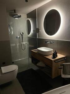 a bathroom with a sink and a toilet and a mirror at FeWo Passo-Palade in Tesimo +65 photos