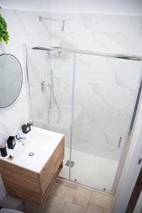 a white bathroom with a shower and a sink at Sapore di Sale in Margherita di Savoia +17 photos