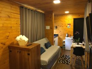 a bedroom with a bed and a desk and a kitchen at Rancho do Tigre in São Joaquim