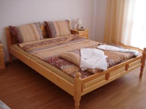 a wooden bed with pillows on it in a bedroom at Prestige in Sinemorets