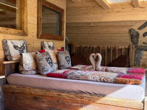 a bed in a log cabin with pillows on it at Bergromantik Ferienwohnung Charisma mit eigener Sauna, Whirlpool und Bergblick in Marktschellenberg
