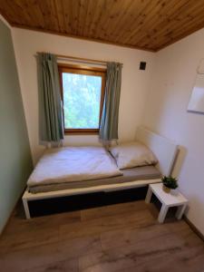 a small bedroom with a bed with a window at Ferienhaus Voigt in Hude