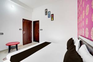 a bedroom with a bed and a red stool at Hotel O Udayraj and Restuarant in Kuchāman