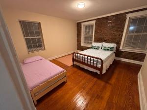a bedroom with two beds and a brick wall at Keur Koura in The Ville in Saint Louis