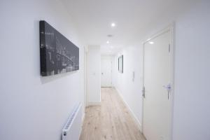 ルートンにあるMidland Apartment I 1-min walk to town centre & station I 8-mins to airport I private balconyの白壁の廊下