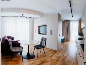 a living room with a table and two chairs at Evo Residence Taietura Turcului in Cluj-Napoca