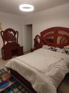a bedroom with a large bed with a wooden headboard at 3 bedrooms apartment in Al Rehab city in New cairo