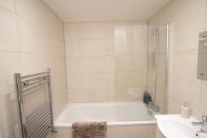 ルートンにあるMidland Apartment I 1-min walk to town centre & station I 8-mins to airport I private balconyのバスタブと洗面台のあるバスルーム