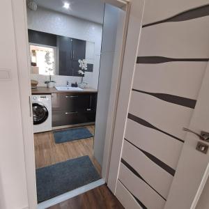 a kitchen with a door leading into a bathroom at Apartament Sikorskiego, klimatyzacja, parking monitoring in Suwałki