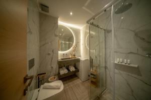 a bathroom with a shower and a toilet and a sink at Lotza apartment Gyalos in Vrontádos
