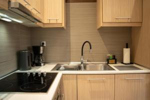 a kitchen with a sink and a coffee maker at Lotza apartment Gyalos in Vrontádos +17 photos