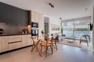 a kitchen and living room with a table and chairs at Enjoy the Space 2BR 2BA Parque Araucano Sector in Santiago