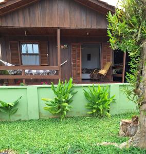 a house with a porch with a chair in front of it at Casa da vó in Morretes +4 photos