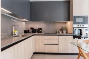 a kitchen with a sink and a stove top oven at Enjoy the Space 2BR 2BA Parque Araucano Sector in Santiago