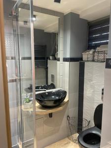 a bathroom with a black sink and a mirror at studio Szymanowskiego 5 in Szczecin