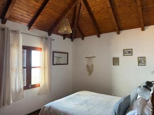 Un dormitorio con una cama y una ventana en Cozy Sea View House Fajã da Ovelha, en Calheta