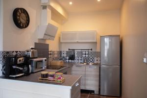 a kitchen with a refrigerator and a clock on the wall at Cathedral Spark in Troyes