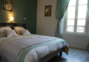 a bedroom with a large bed and two windows at Cathedral Spark in Troyes