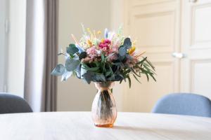 a glass vase with a bouquet of flowers on a table at Cathedral Spark in Troyes +21 photos