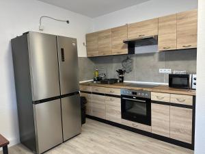 a kitchen with a stainless steel refrigerator and wooden cabinets at Haus Wolf in Kaiserslautern
