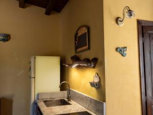 a kitchen with a sink and a refrigerator at Casa Pizzuta in Noto +76 photos