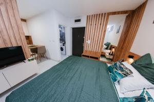 a bedroom with a large bed and a television at Apartment Vukeljic in Doboj