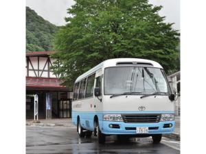 un bus blanc et bleu garé dans un parking dans l'établissement Hotel Tetora Resort Tateyama Kokusai - Vacation STAY 55719v, à Tateyama