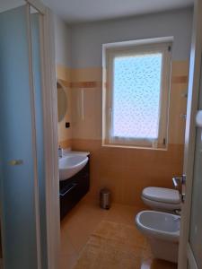 a bathroom with a sink and a toilet and a window at Casa Emma in Torre Pellice +25 photos