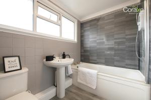 a bathroom with a sink and a toilet and a tub at Stylish 3BR Home in Rowley Regis in Rowley Regis +35 photos