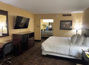 a hotel room with a bed and a flat screen tv at MCM Grande FunDome Odessa in Odessa