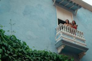 two women on a balcony of a building at Hotel Villa Alta Guest House in Cartagena de Indias +53 photos