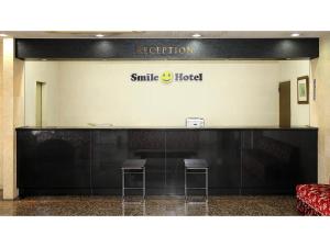 un segno per un hotel sorridente con due sgabelli di Smile Hotel Fukuoka Okawa - Vacation STAY 81556v a Ōkawa