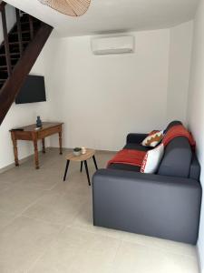 a living room with a couch and a table at Maison typique de village in Sorbo-Ocagnano
