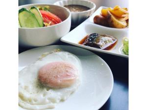 un piatto di cibo con un uovo fritto su un tavolo di Smile Hotel Fukuoka Okawa - Vacation STAY 81553v a Ōkawa