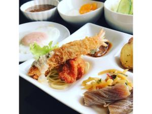 une assiette de nourriture avec du poisson, des pâtes et d'autres aliments dans l'établissement Smile Hotel Fukuoka Okawa - Vacation STAY 81529v, à Ōkawa