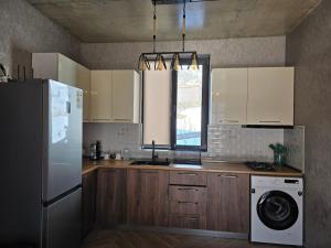 una cucina con frigorifero e lavatrice di Kazbegi Folk Cottages a Kazbegi