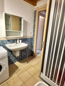 Un baño con lavabo y lavadora. en Casa vacanze Le Dune, en Policoro