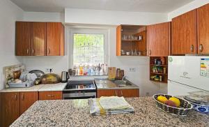 a kitchen with wooden cabinets and a counter top at The best Riverfront house in SJJ