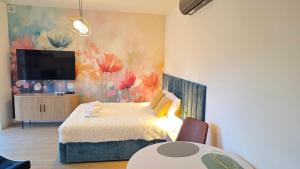 ボシュコボにあるBoszkowo Horizon Park Apartament 14 "Laguna"のベッドと壁掛けテレビのある寝室