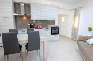 cocina con mesa, sillas y sofá en Antonelli Apartment, en Terracina