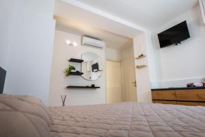 1 dormitorio con cama, espejo y TV en Antonelli Apartment, en Terracina