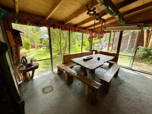 a picnic table and benches in a room with windows at Cabañas Los Volcanes Ensenada Puerto Varas in Ensenada +43 photos
