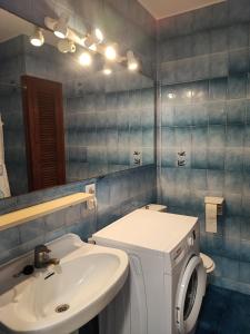 Un baño con lavabo y lavadora. en Apartamento colibrí, en Alaior