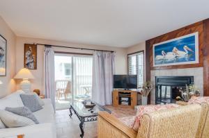 a living room with a white couch and a fireplace at Waves N At by Bryant Real Estate in Kure Beach
