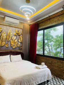 a bedroom with a bed and a large window at Sunshine villa thuan an in Hue