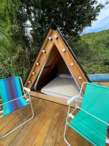 twee stoelen en een bed in een tent bij Smart camping Caçandoca in Ubatuba