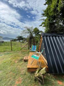 een paar stoelen op een houten terras bij Smart camping Caçandoca in Ubatuba
