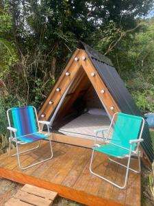 twee stoelen op een terras met een tent bij Smart camping Caçandoca in Ubatuba