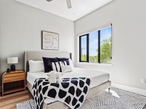 una camera da letto con un letto con una coperta bianca e nera di Flawless New Modern Magnolia Townhome a Fort Worth